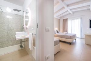 a white bathroom with a bed and a sink at Palazzo Michelangelo in Villasimius