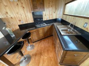 a kitchen with a sink and two stools at Casa al mare due - Matanzas y Pupuya in Navidad