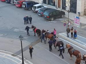eine Gruppe von Menschen, die Pferde entlang einer Stadtstraße laufen in der Unterkunft APARTAMENTOS GORI SUITES HIDROMASAJE accesibles minusválidos in Villafranca del Cid