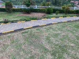 a cobblestone sidewalk with yellow lines on it at Ishuro Villas in Rukungiri