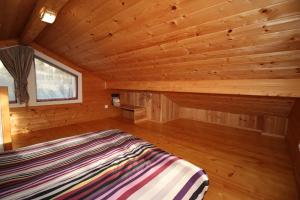a bedroom with a bed in a wooden cabin at Les Epiceas in Chorges