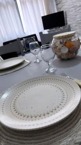 een tafel met een witte plaat en glazen erop bij Apartamento 2 Guarujá enseada 2 dorm, 200m praia Ed Carpentier in Guarujá