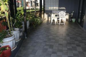 Ostro Hotel في بنوم بنه: فناء مع طاولة وكراسي والنباتات الفخارية