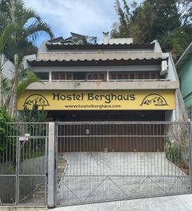 uma barbearia de hostel com uma cerca em frente em Hostel Berghaus em Florianópolis