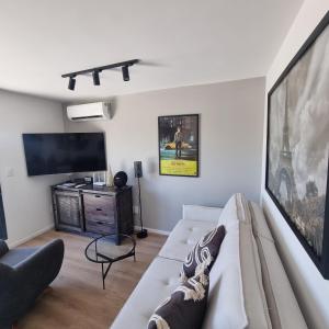 sala de estar con sofá y TV de pantalla plana en Exclusivo Penthouse en Cordon Soho con Parking y STARPLUS incluidos en Montevideo