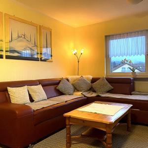 Una sala de estar con un sofá marrón y una mesa. en Ferienwohnung Wolff, Kelkheim, en Kelkheim