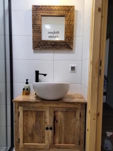 baño con lavabo blanco en un armario de madera en Domek nad Zegrzem, en Arciechow