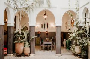 una sala da pranzo con piante in vaso e un tavolo di Riad Alnadine a Marrakech