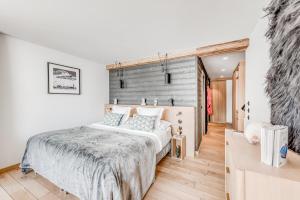 a bedroom with a large bed and a wooden wall at Le Yule Hotel & Spa in Val dʼIsère