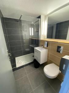 a bathroom with a toilet and a sink and a mirror at Campanile Saumur in Saumur