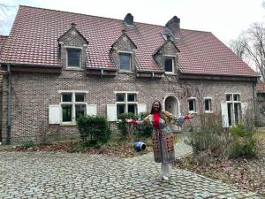 KeerbergenにあるKaribu Keerbergenの煉瓦造りの家の前に立つ女