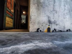 uma sala vazia com uma parede de pedra e um objecto amarelo em Sela Stay em Yogyakarta