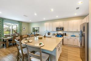 eine Küche und ein Esszimmer mit einer großen Insel in der Mitte in der Unterkunft Lake Breeze at Ellis Exclusive Villas in Kissimmee