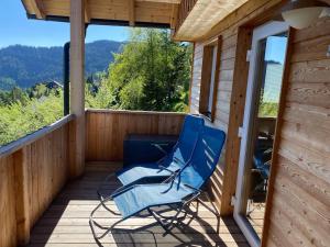 una silla azul sentada en el porche de una cabaña en Chalet Schröder, en Klippitztorl