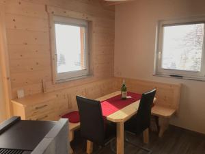 een eetkamer met een tafel met een fles wijn erop bij Chalet Schröder in Klippitztorl