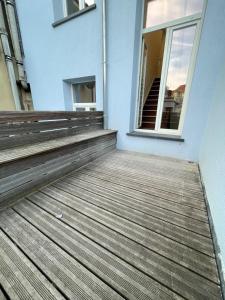 a wooden deck outside of a building with a window at Cozy South-Up and Ground in Brussels