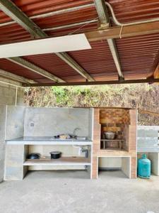 una cocina al aire libre con estanterías blancas y techo de madera en Case Vi d' o', en Le Tampon