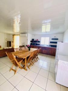 a kitchen with a wooden table and a refrigerator at Case Vi d' o' in Le Tampon +17 photos