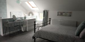 a bedroom with a bed and a vanity and a sink at The Stables in Tregaron