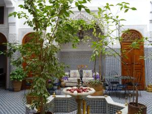 sala de estar con sofá y mesa con plantas en Dar Al Safadi, en Fez