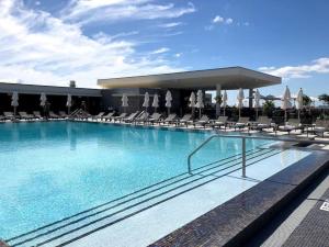 a large swimming pool with chairs and umbrellas at Beachside Luxury KING Suite in 4 Star Resort with Rooftop Bar and Pool in Hollywood