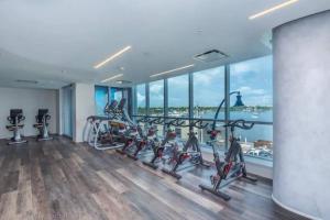 a gym with treadmills and ellipticals and a large window at Beachside Luxury KING Suite in 4 Star Resort with Rooftop Bar and Pool in Hollywood