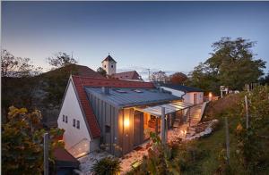 a house on top of a hill with a church at WEINVIERTLER KELLERSTÖCKL Weingut Hindler in Schrattenthal