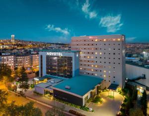 a hotel building with a blue roof at night at Novotel Gaziantep in Gaziantep