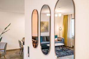 een woonkamer met een bank en 2 spiegels bij Moderne 3 Zi-FeWo "Vintage Style" 70 qm Nähe Freiburg in Simonswald