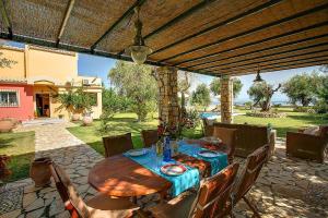 uma mesa de madeira e cadeiras em um pátio em Cote Jardin em Barbati