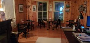 a restaurant with wooden walls and tables and chairs at Amherst Shore Country Inn in Lorneville