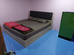 a bed with two towels on it in a room at บ้านสวนนกโฮมสเตย์ OWLHOUSE in Ban Pong Pat