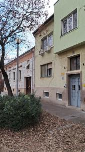 um edifício com uma porta azul ao lado em Eper Apartman em Szeged