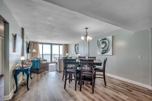 a dining room and living room with a table and chairs at Carolina Dunes - 503 in Myrtle Beach