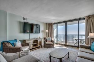 a living room with a couch and chairs and a tv at Carolina Dunes - 503 in Myrtle Beach