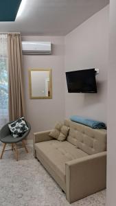 uma sala de estar com um sofá e uma televisão de ecrã plano em Eper Apartman em Szeged