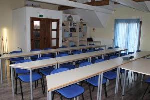 a classroom with rows of tables and blue chairs at Rooms & Apartment Vinia in Bjelovar