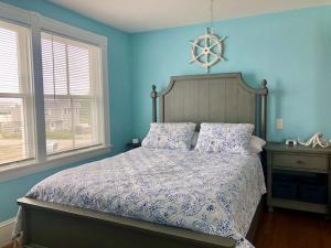 1 dormitorio con 1 cama con paredes y ventanas azules en Broadway Cottage- York Beach Oceanfront w/ Incredible Views, en York