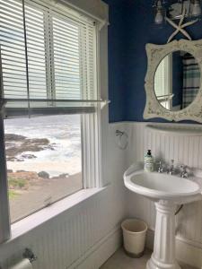 baño con lavabo, espejo y ventana en Broadway Cottage- York Beach Oceanfront w/ Incredible Views, en York