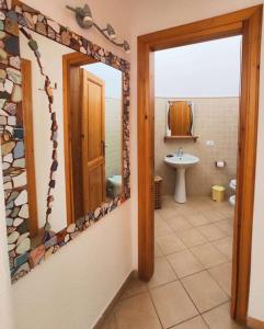 ein Badezimmer mit einem Spiegel und einem Waschbecken in der Unterkunft Casa Ischia in Ischia