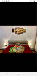 Un dormitorio con una cama roja con cuadros en la pared en Magic Casanova Flat in the heart of Venice en Venecia