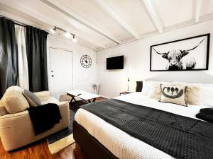 a bedroom with a bed and a cow on the wall at Studio C by Breckler Park in Perth