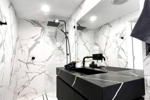 a bathroom with a black sink and marble walls at Studio C by Breckler Park in Perth