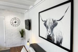 a picture of a cow hanging on a wall at Studio C by Breckler Park in Perth