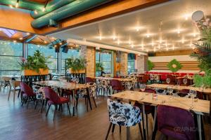 um restaurante com mesas e cadeiras num quarto em 103 View Park Hotel & SPA em Panichishte