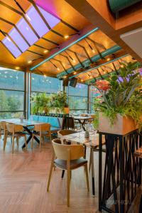 a restaurant with tables and chairs and windows at 103 View Park Hotel & SPA in Panichishte