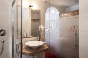 a bathroom with a sink and a glass shower at Garni B&B Schenk in Selva di Val Gardena +38 photos