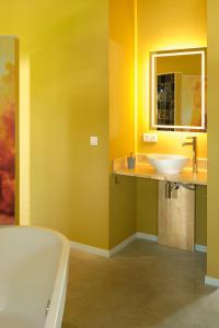 een badkamer met een bad, een wastafel en een spiegel bij Achterhoeks Goed, Bed & Breakfast in Vragender in Vragender