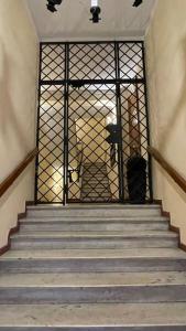 uma escada com um portão com escadas que levam a um edifício em Vicolo San Trifone Cosy House em Roma