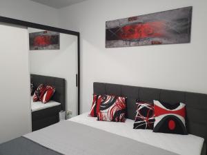 a bedroom with a bed with red and black pillows at Moderne Ferienwohnung mit Balkon direkt an der Peene in Ziemitz